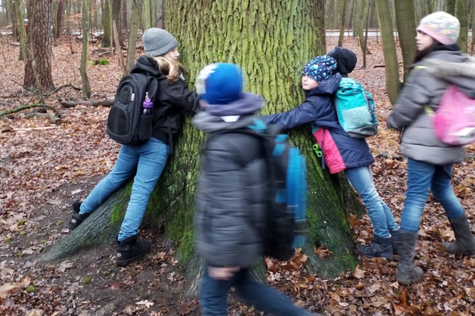 Kindergruppe umarmt einen Baum - Foto: Christine Kuhnert
