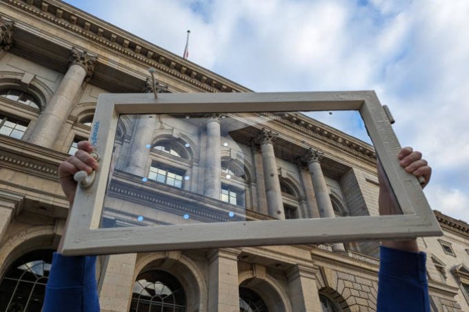 Ein Fenster mit Klebepunkten zum Schutz vor Vogelschlag wird vor dem Abgeordnetenhaus hochgehalten.